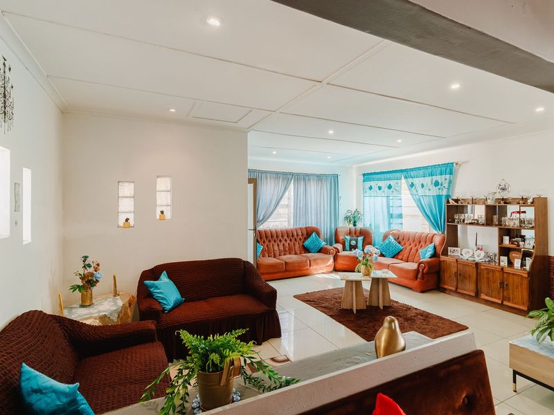 Spacious living area featuring tiled flooring, recessed downlighting, and decorative glass block wall inserts, offering a bright and open layout.