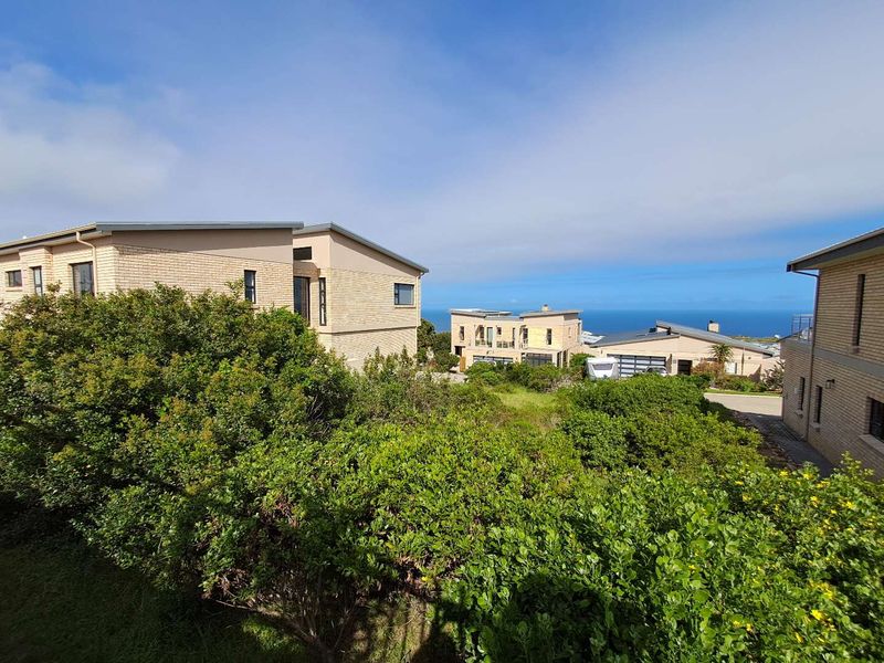 A scenic elevated view overlooking the surrounding residential estate with a clear outlook towards the ocean horizon.