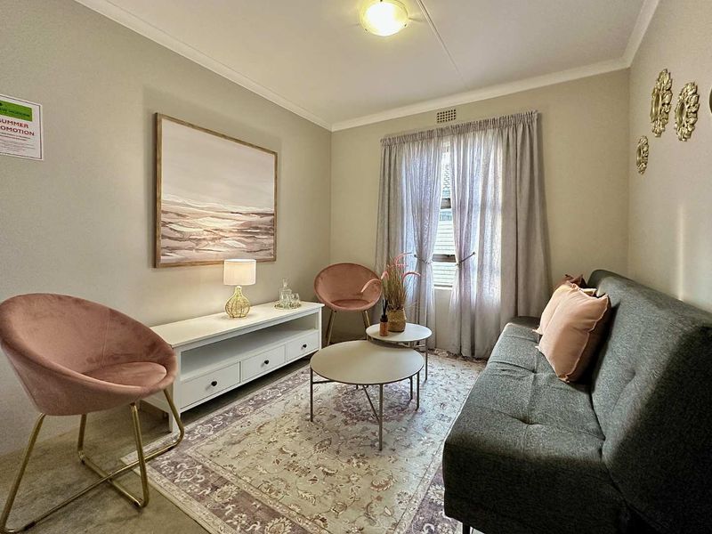 A cozy living room featuring neutral wall tones, coving, and a ceiling vent, providing a comfortable and functional space.