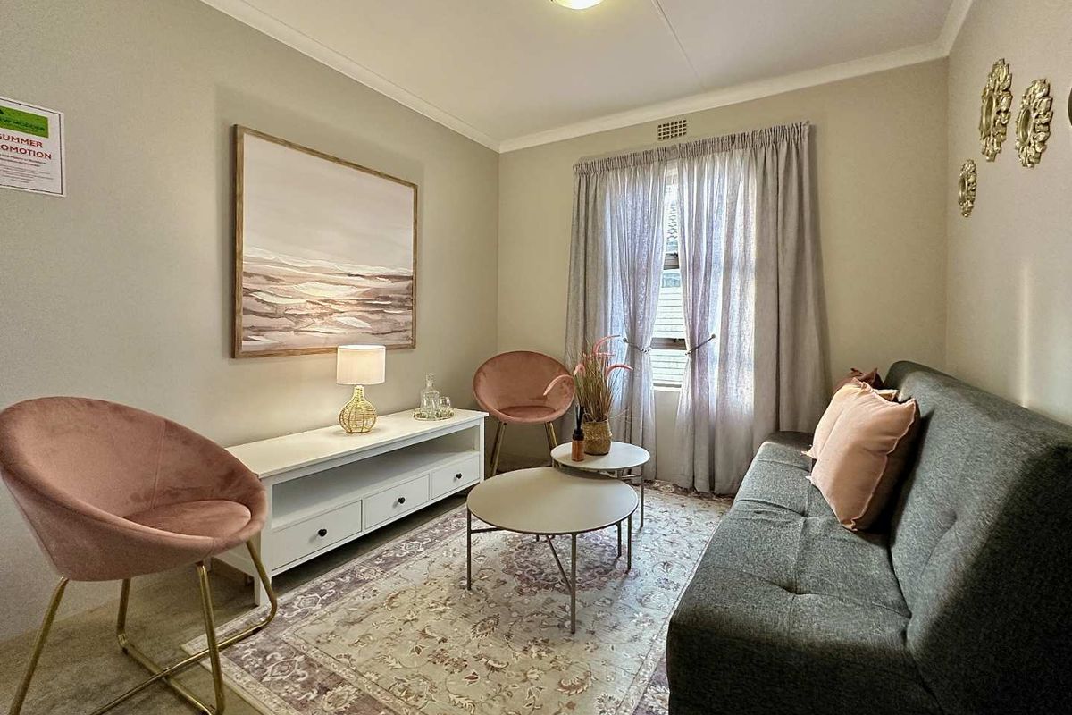 A cozy living room featuring neutral wall tones, coving, and a ceiling vent, providing a comfortable and functional space.