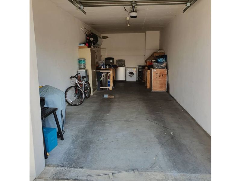 A functional garage space featuring concrete flooring, a sectional door, and integrated laundry plumbing connections for added utility.