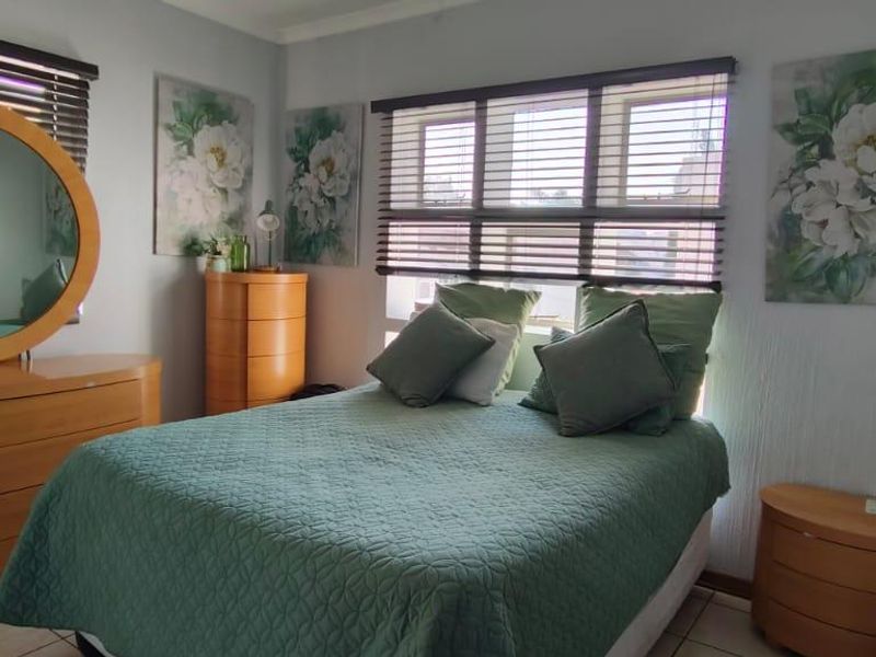 A functional bedroom featuring tiled flooring and venetian blinds, offering a neutral base for personalization.