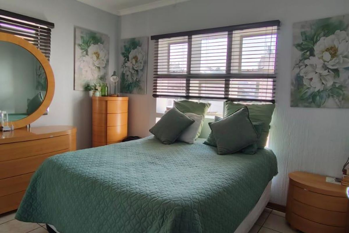 A functional bedroom featuring tiled flooring and venetian blinds, offering a neutral base for personalization.