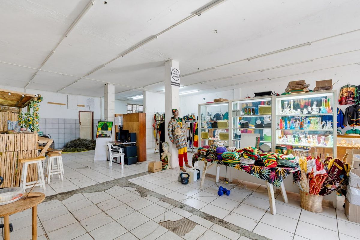 Open-plan retail space featuring tiled flooring, structural columns, and built-in display shelving, suitable for various commercial business applications.