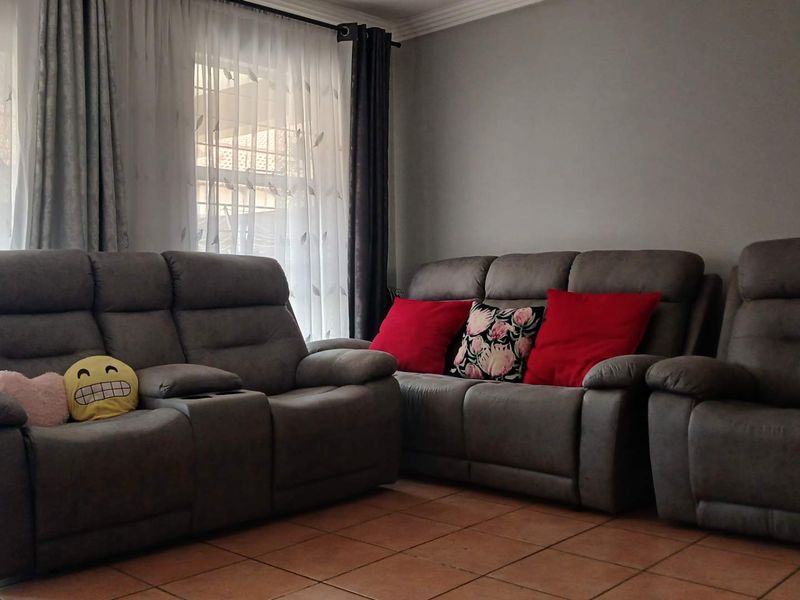 A living room area featuring tiled flooring and decorative ceiling cornicing, providing a neutral base for interior design.
