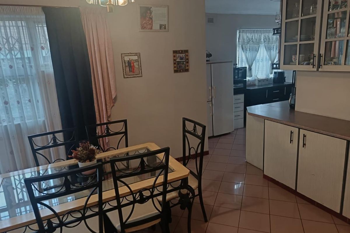 Open plan dining and kitchen area featuring tiled flooring and functional built-in cabinetry with laminate countertops.