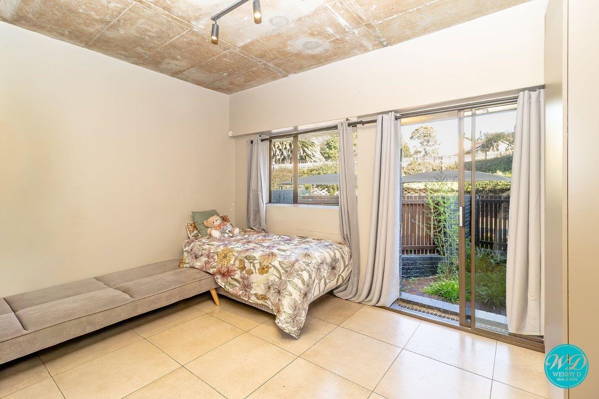 Bedroom featuring an exposed concrete ceiling, tiled flooring, and sliding glass doors providing direct access to the outdoor area.