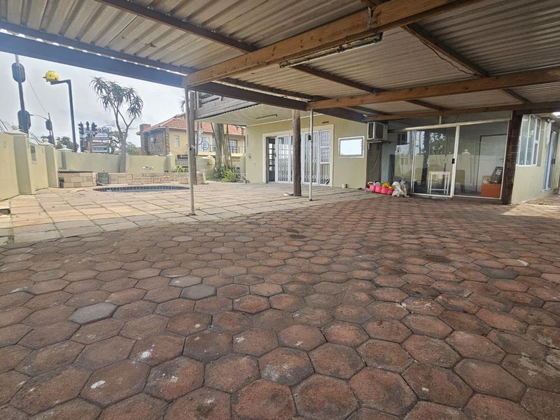 A spacious covered patio area featuring paved flooring and direct access to the interior through sliding glass doors.
