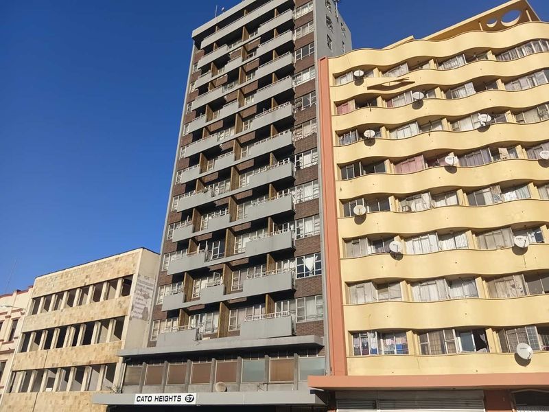Exterior view of the Cato Heights apartment building, featuring a multi-story facade with individual balconies and street-level signage.