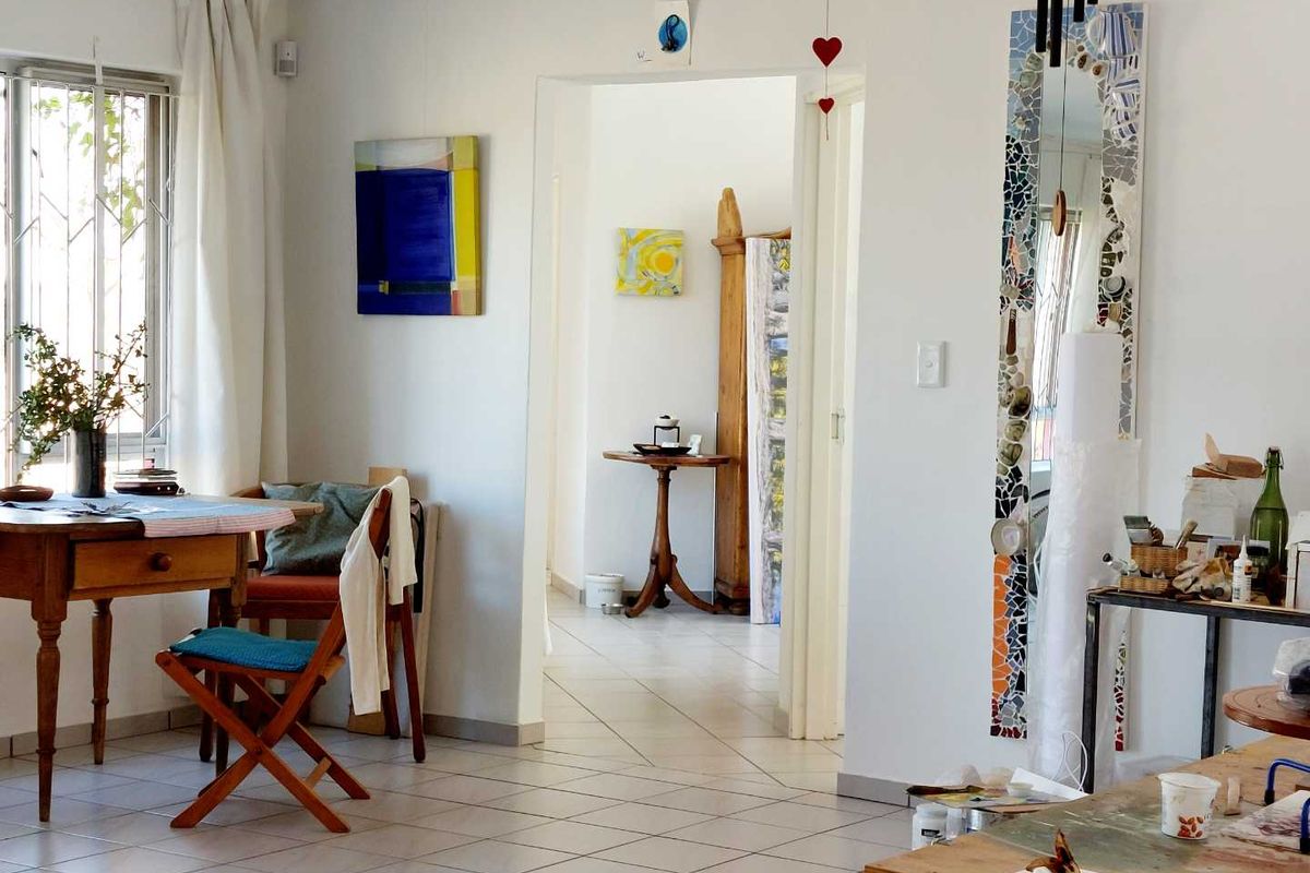A bright living area featuring tiled flooring and a doorway leading to an adjacent room, providing a functional and open layout.