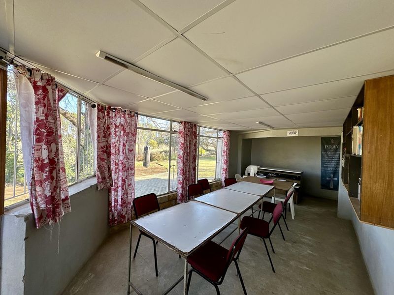 Enclosed patio area featuring large windows, built-in shelving, and a functional layout suitable for a dining or multi-purpose space.