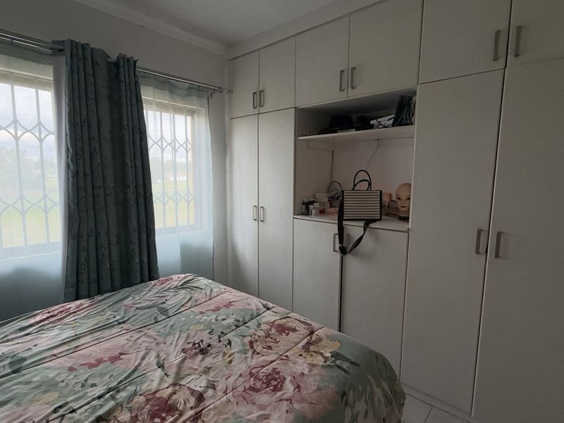 A bedroom featuring extensive built-in cabinetry and windows fitted with security bars, offering functional storage and natural light.