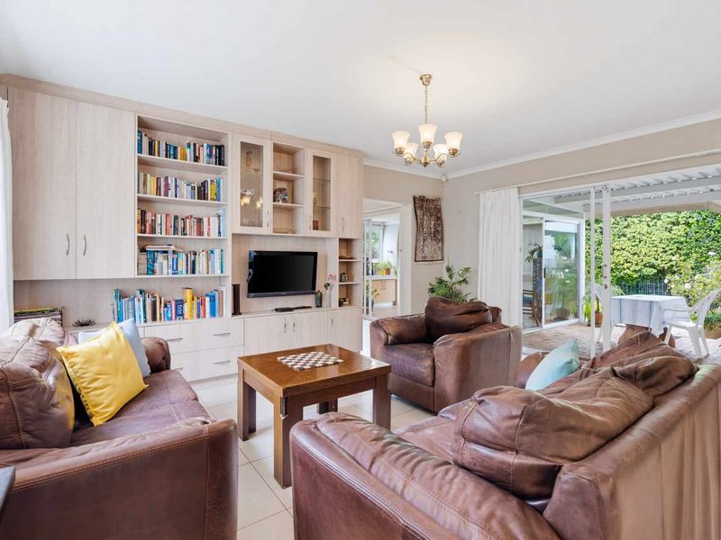 Spacious living room featuring built-in cabinetry, tiled flooring, and large sliding glass doors that provide seamless access to the outdoor patio area.