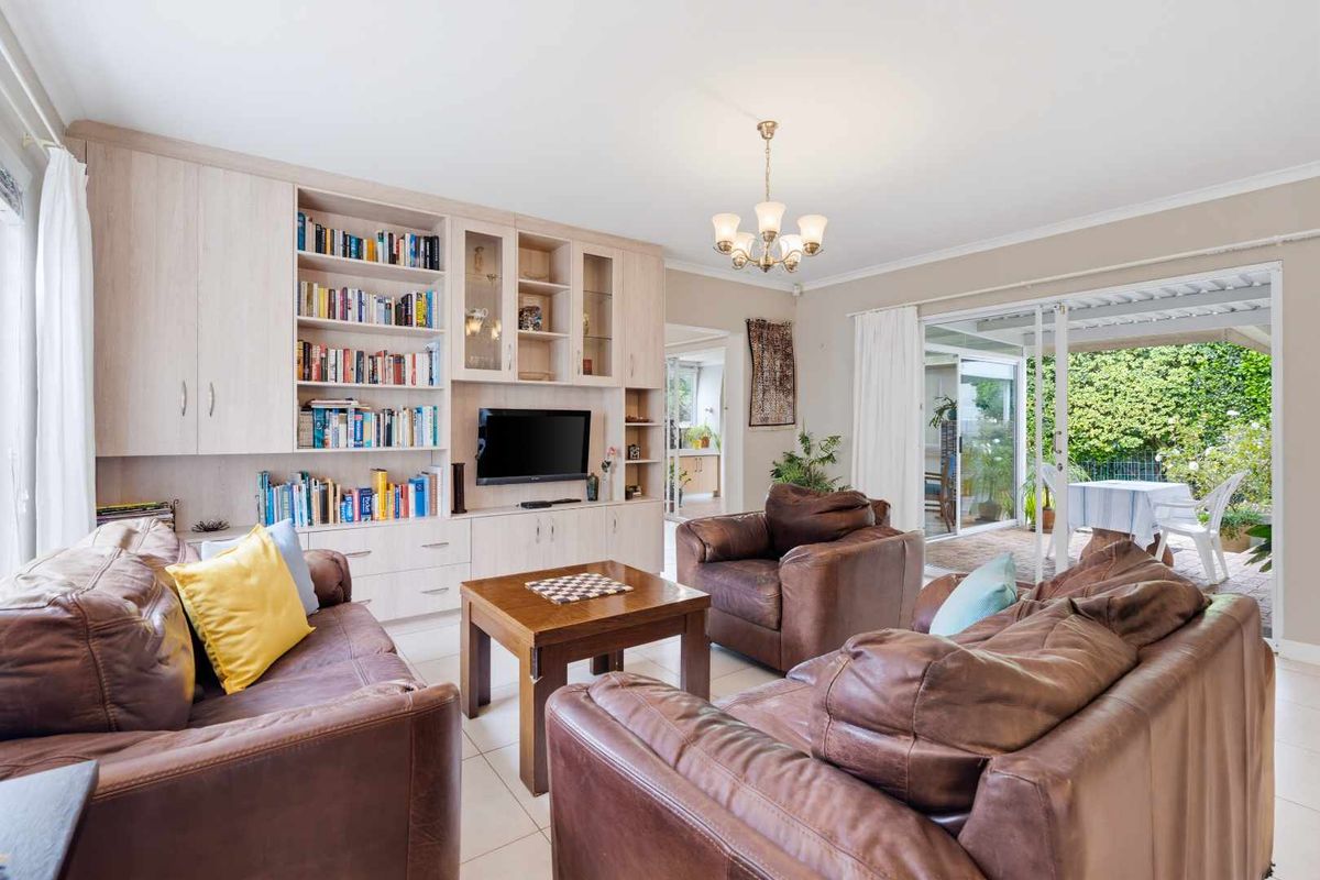 Spacious living room featuring built-in cabinetry, tiled flooring, and large sliding glass doors that provide seamless access to the outdoor patio area.