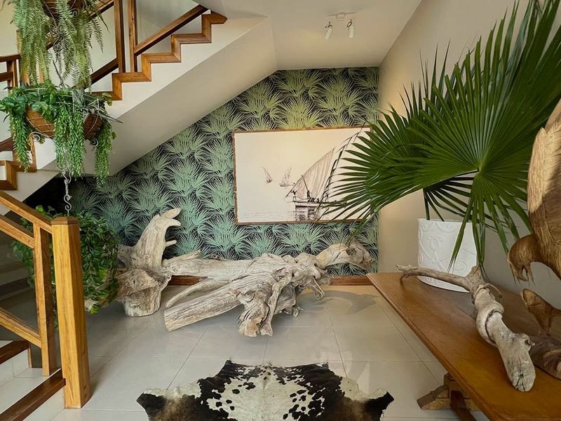 Welcoming entrance hall featuring a wooden staircase and decorative patterned wallpaper, creating a warm and inviting atmosphere.