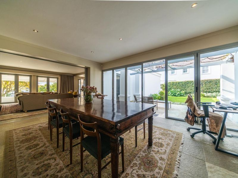 Spacious open-plan dining area featuring large format floor tiles, recessed lighting, and expansive aluminium sliding doors providing seamless access to the rear garden.