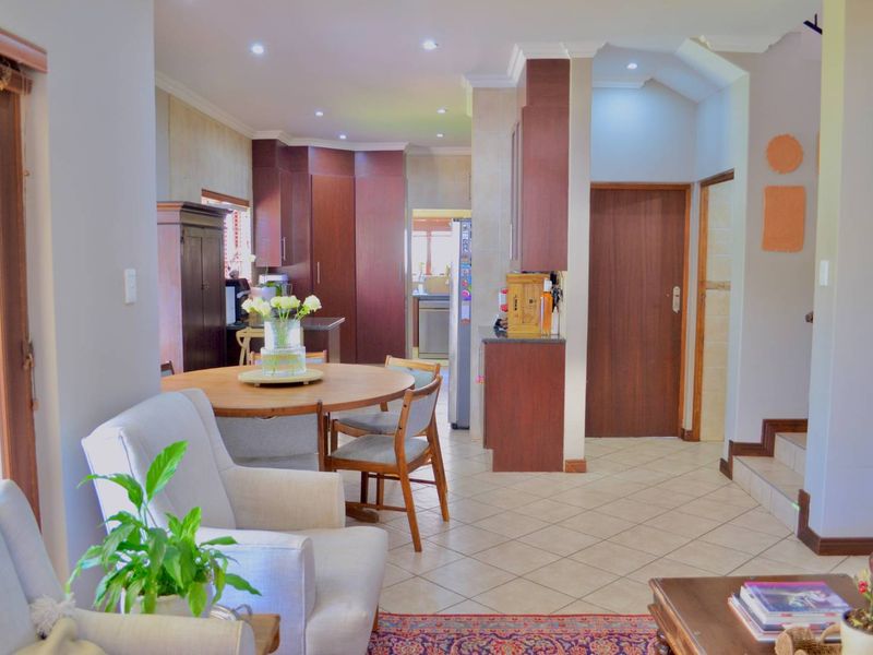 An open-plan living and dining area featuring tiled floors, recessed lighting, and integrated cabinetry, creating a functional and connected space.