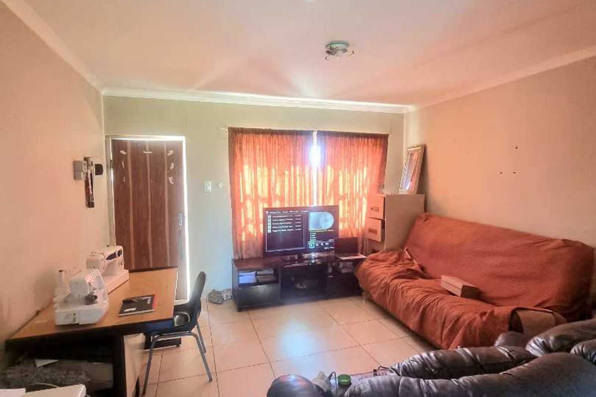 A functional living room featuring tiled flooring and a standard layout, providing a comfortable space for daily relaxation.