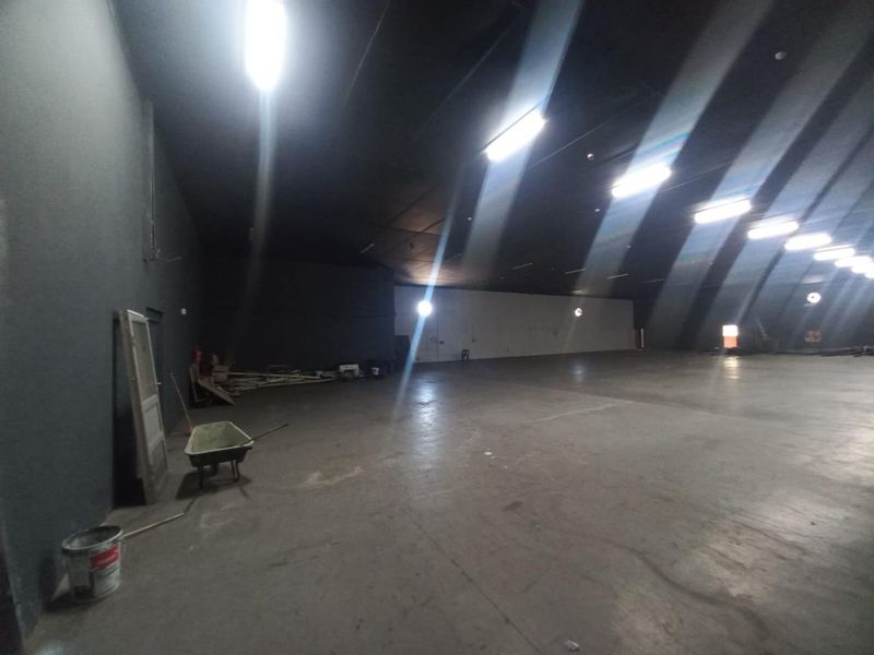A large, open-plan industrial utility space featuring concrete flooring and overhead fluorescent lighting, suitable for warehouse or workshop use.
