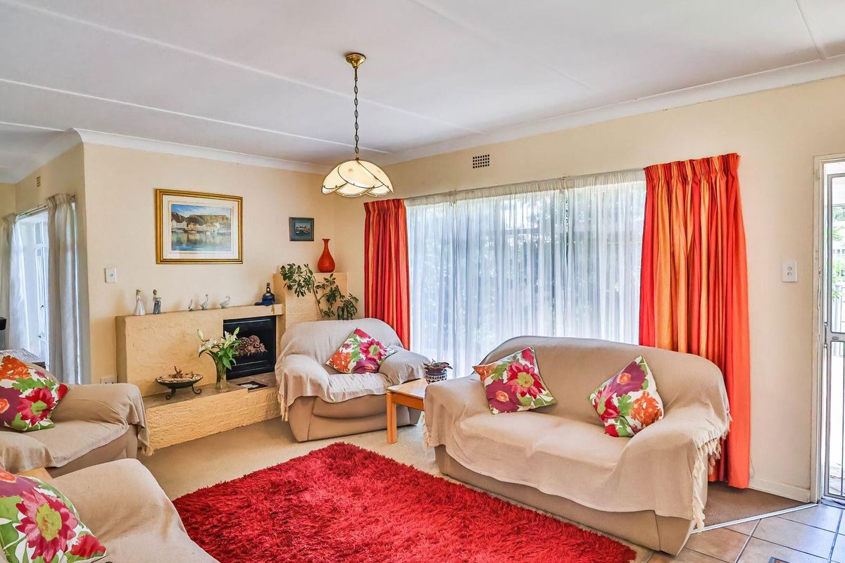 A comfortable living room featuring a built-in fireplace, large windows with natural light, and direct access to the exterior through a security door.