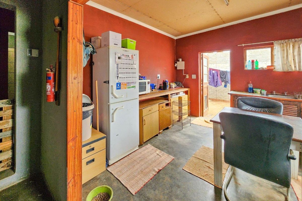 A functional kitchen area featuring built-in cabinetry, a sink, and direct access to an outdoor space.