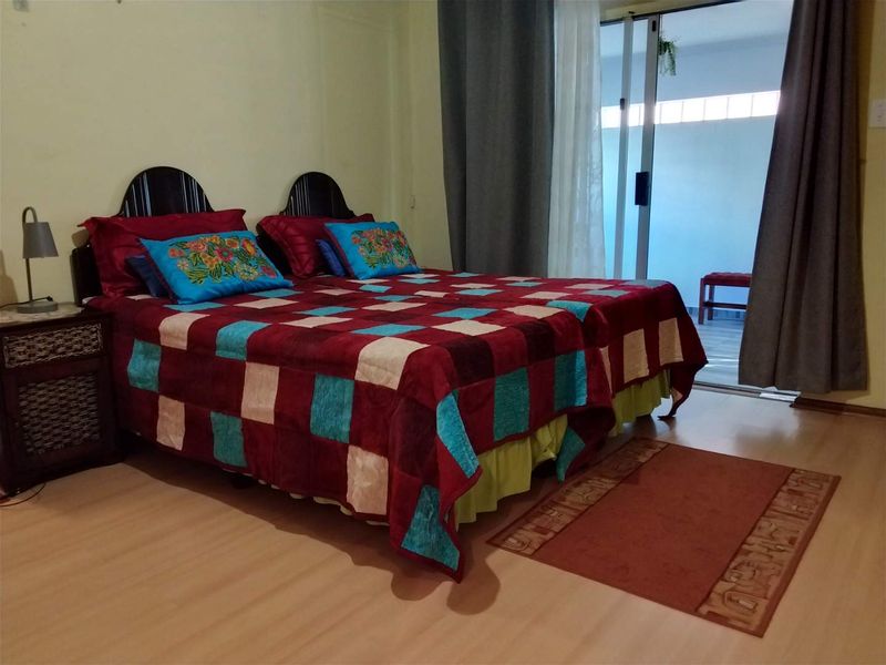 A bedroom featuring laminate flooring and a sliding glass door providing access to an outdoor area.