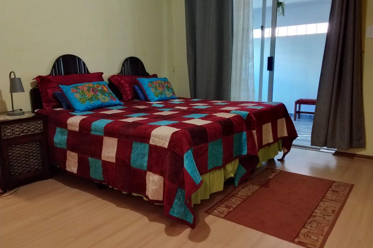 A bedroom featuring laminate flooring and a sliding glass door providing access to an outdoor area.
