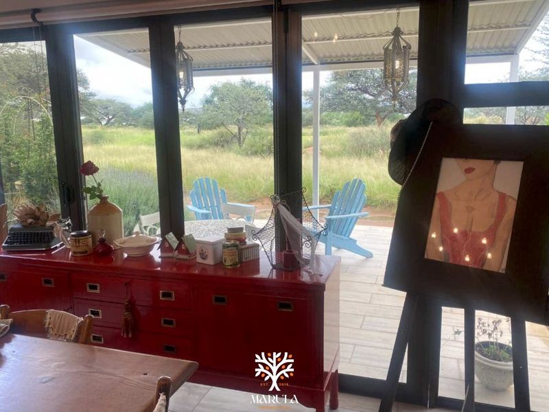 Bright living area featuring large glass sliding doors that open onto a covered patio with scenic views of the surrounding landscape.