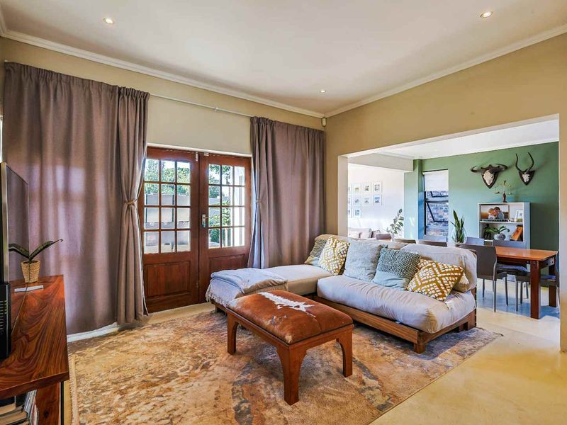 Open plan living and dining area featuring tiled flooring, recessed downlighting, and double french doors leading to the exterior.