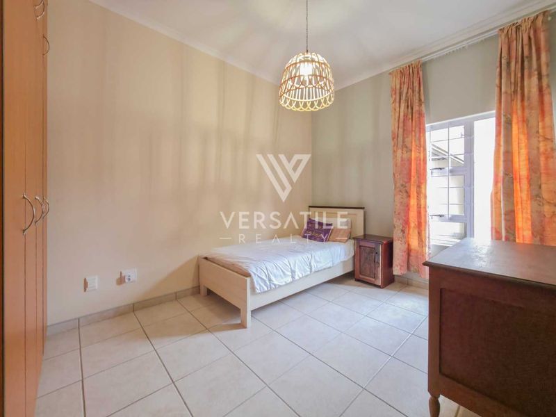 A functional bedroom featuring tiled flooring, a built-in wardrobe, and a coved ceiling, providing a neutral space ready for personalization.