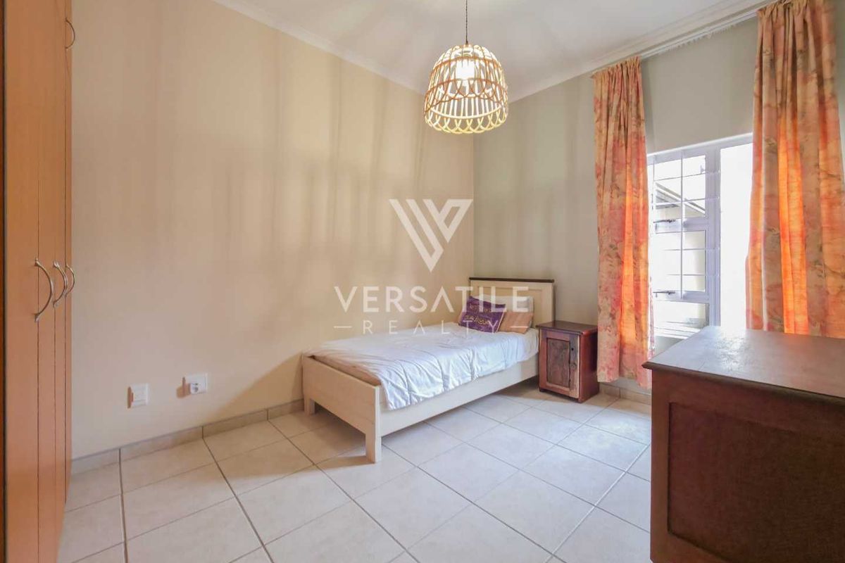 A functional bedroom featuring tiled flooring, a built-in wardrobe, and a coved ceiling, providing a neutral space ready for personalization.