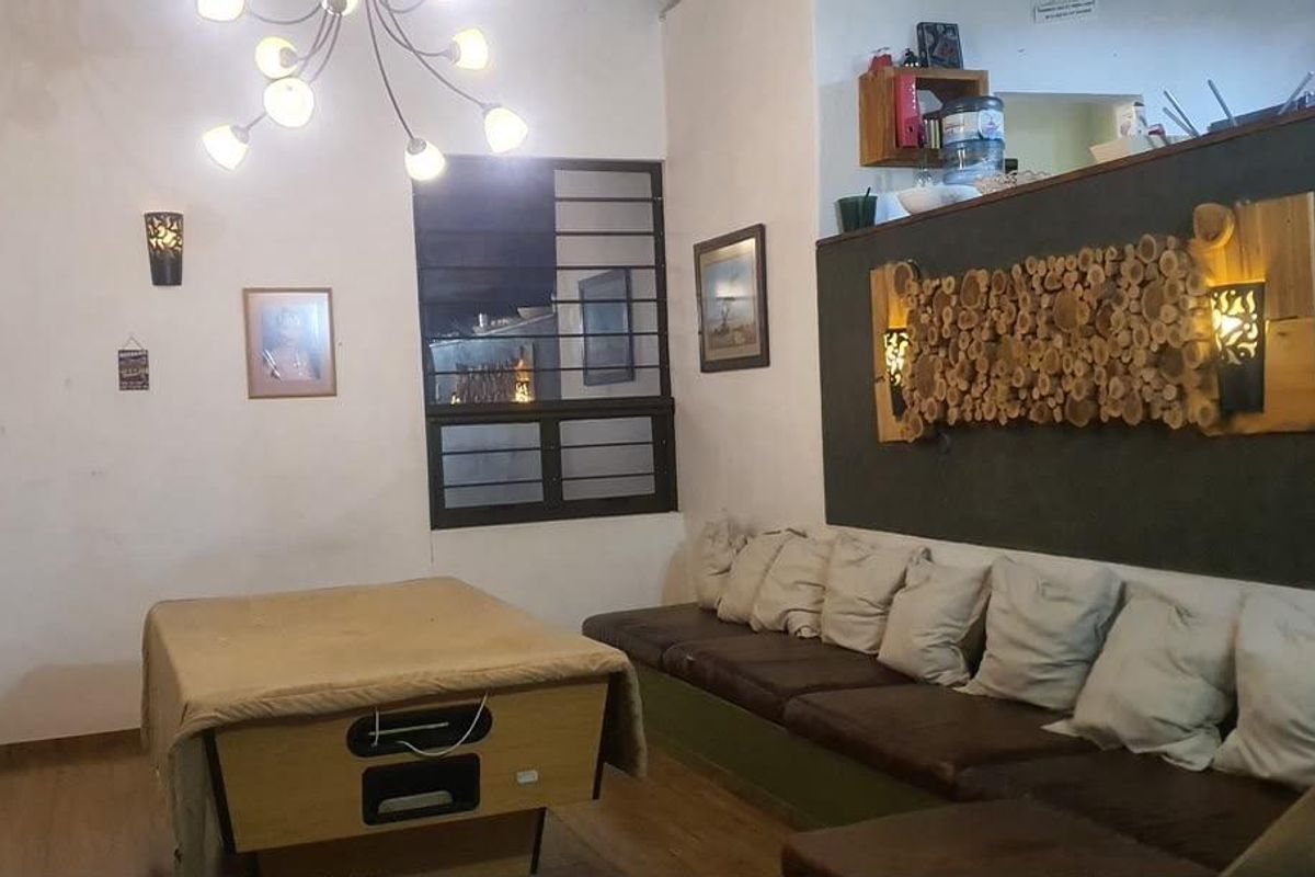A living area featuring laminate flooring, a built-in bench seating arrangement, and a feature wall with decorative wood elements.
