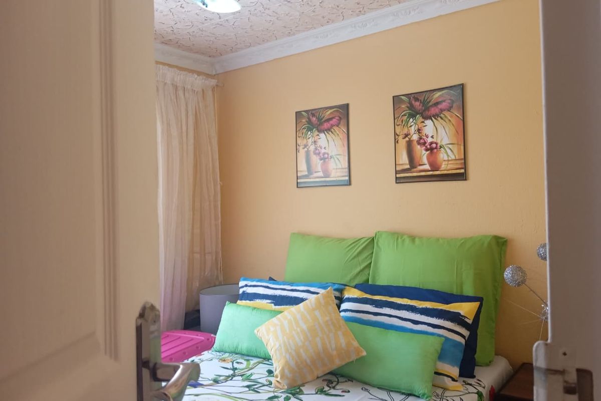 A bedroom featuring decorative ceiling tiles and crown molding, viewed from the doorway.