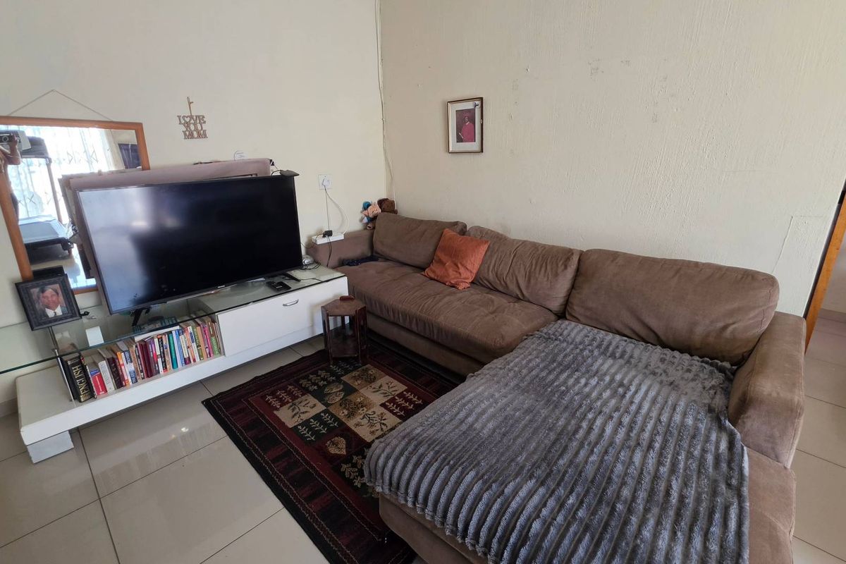 A living room area featuring tiled flooring and neutral wall finishes, providing a functional space for relaxation.