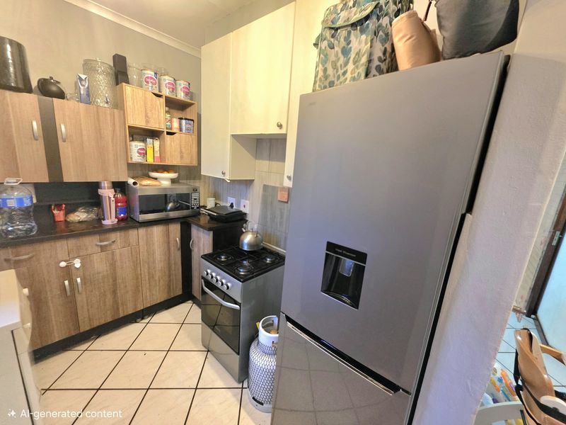 A compact kitchen featuring laminate cabinetry, tiled flooring, a gas stove, and a tiled backsplash, offering functional storage and preparation space.