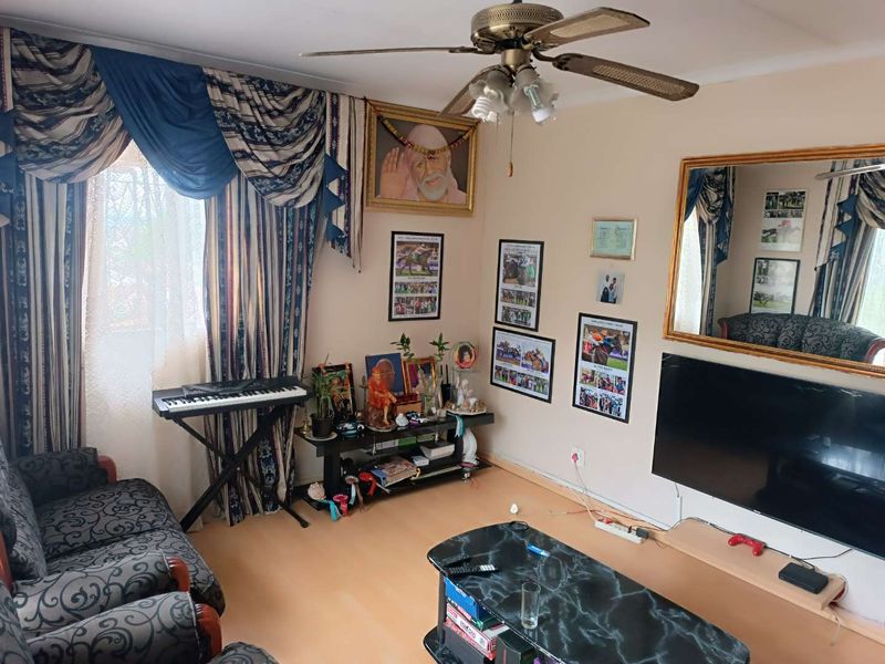 A living room featuring laminate flooring and a ceiling fan, providing a functional space for relaxation.
