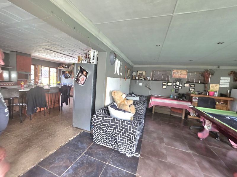 An open-plan living and kitchen area featuring tiled flooring and recessed ceiling lighting, providing a functional space for daily living and entertaining.