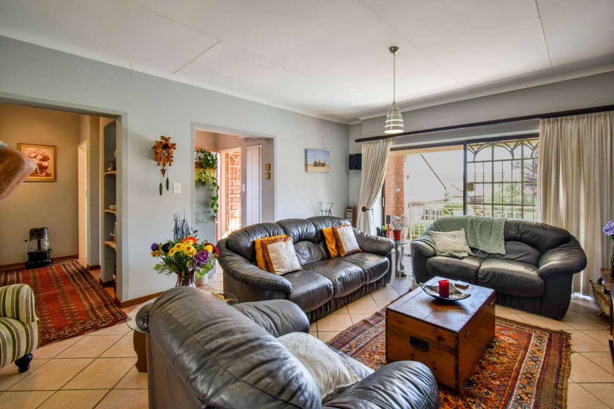 Spacious living room featuring tiled flooring and a large sliding glass door providing access to the outdoor area.