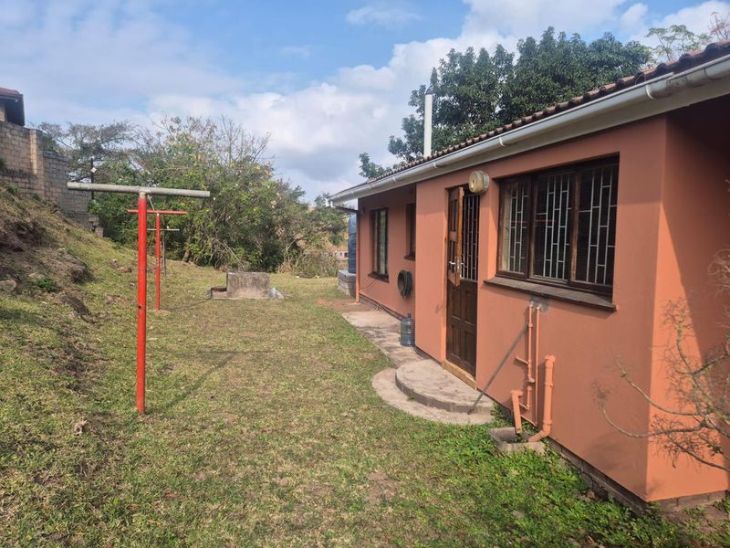 Rear exterior view of the property showing the back facade, garden area, and fixed exterior infrastructure.