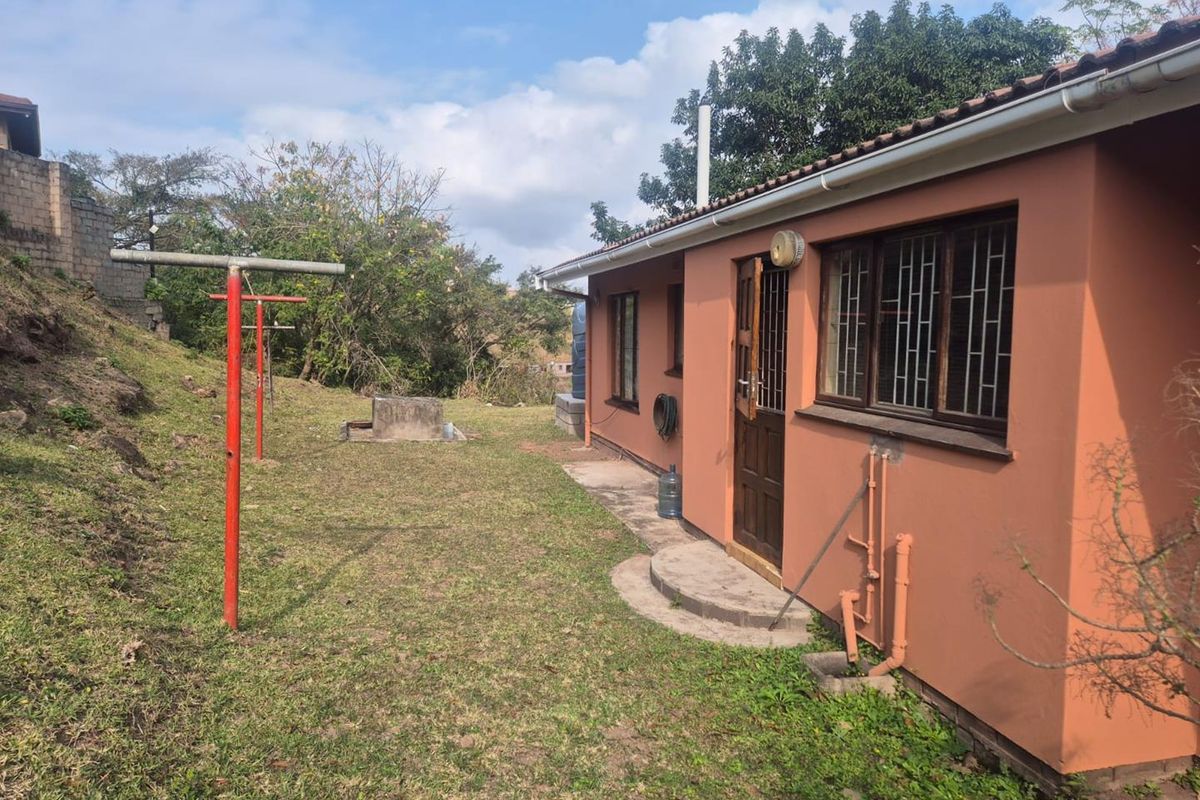 Rear exterior view of the property showing the back facade, garden area, and fixed exterior infrastructure.