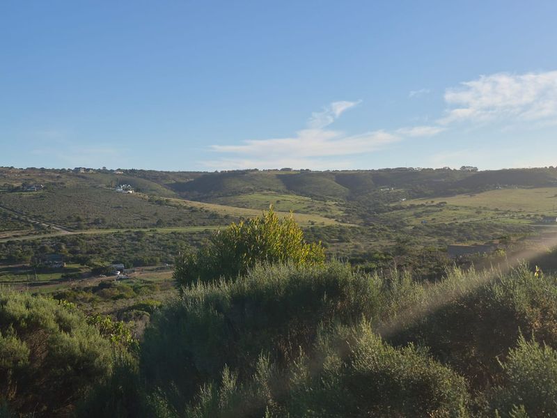 A scenic landscape view showcasing the natural rolling hills and vegetation surrounding the vacant residential property.