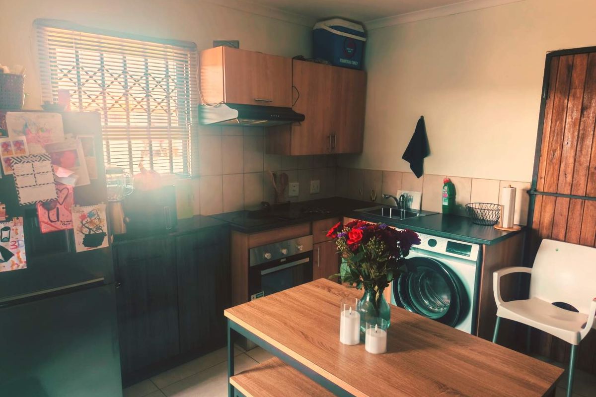 Compact kitchen featuring built-in cabinetry, integrated oven, extractor fan, and tiled backsplash with a functional layout.