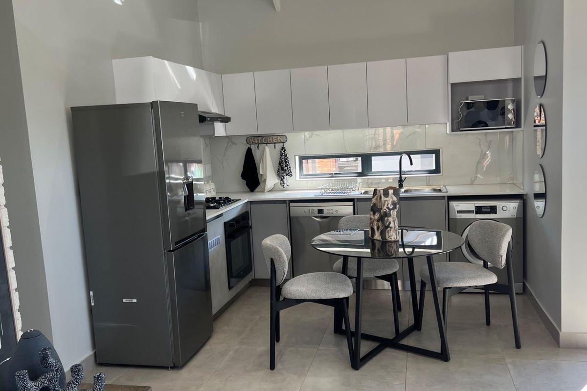 Modern kitchen featuring sleek white cabinetry, stone-look splashback, integrated appliances, and tiled flooring, offering a clean and functional culinary space.