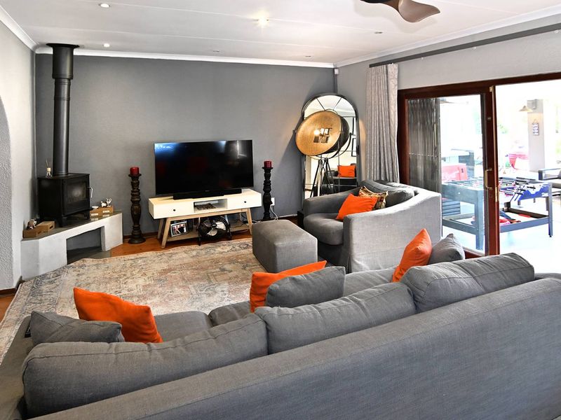 A comfortable living room featuring a modern freestanding fireplace, recessed lighting, and large sliding glass doors that provide access to the outdoor patio area.