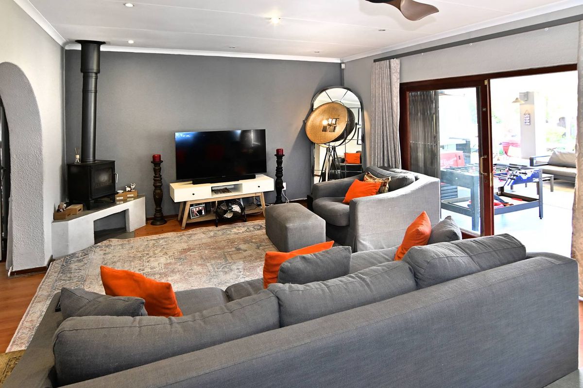 A comfortable living room featuring a modern freestanding fireplace, recessed lighting, and large sliding glass doors that provide access to the outdoor patio area.