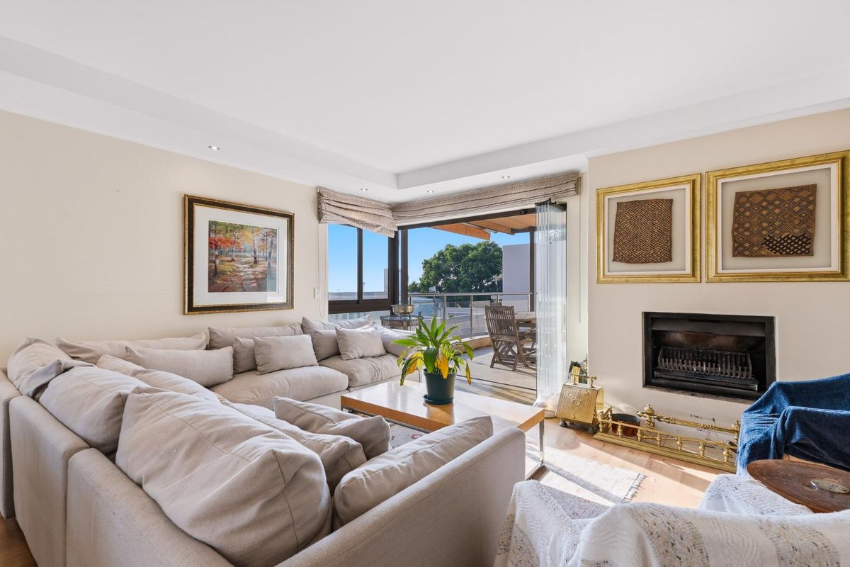 A bright living room featuring a built-in fireplace and large sliding glass doors that open onto an outdoor balcony area.
