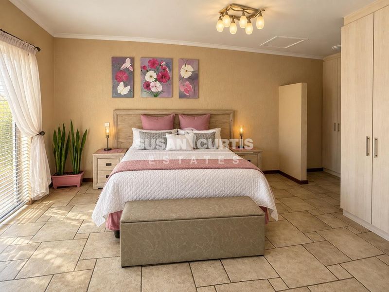 Spacious bedroom featuring tiled flooring, built-in cupboards, and a sliding glass door providing natural light.