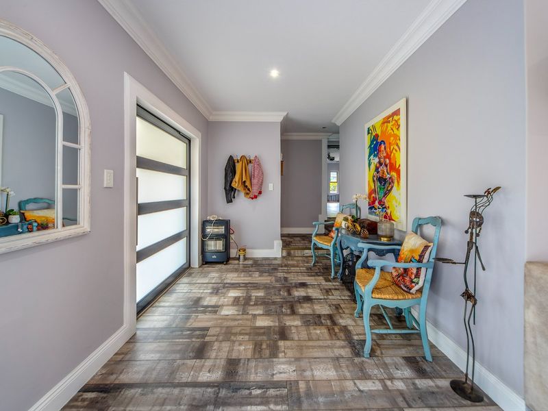 Welcoming entrance hall featuring modern wood-look tile flooring, crown molding, and a contemporary frosted glass panel front door.