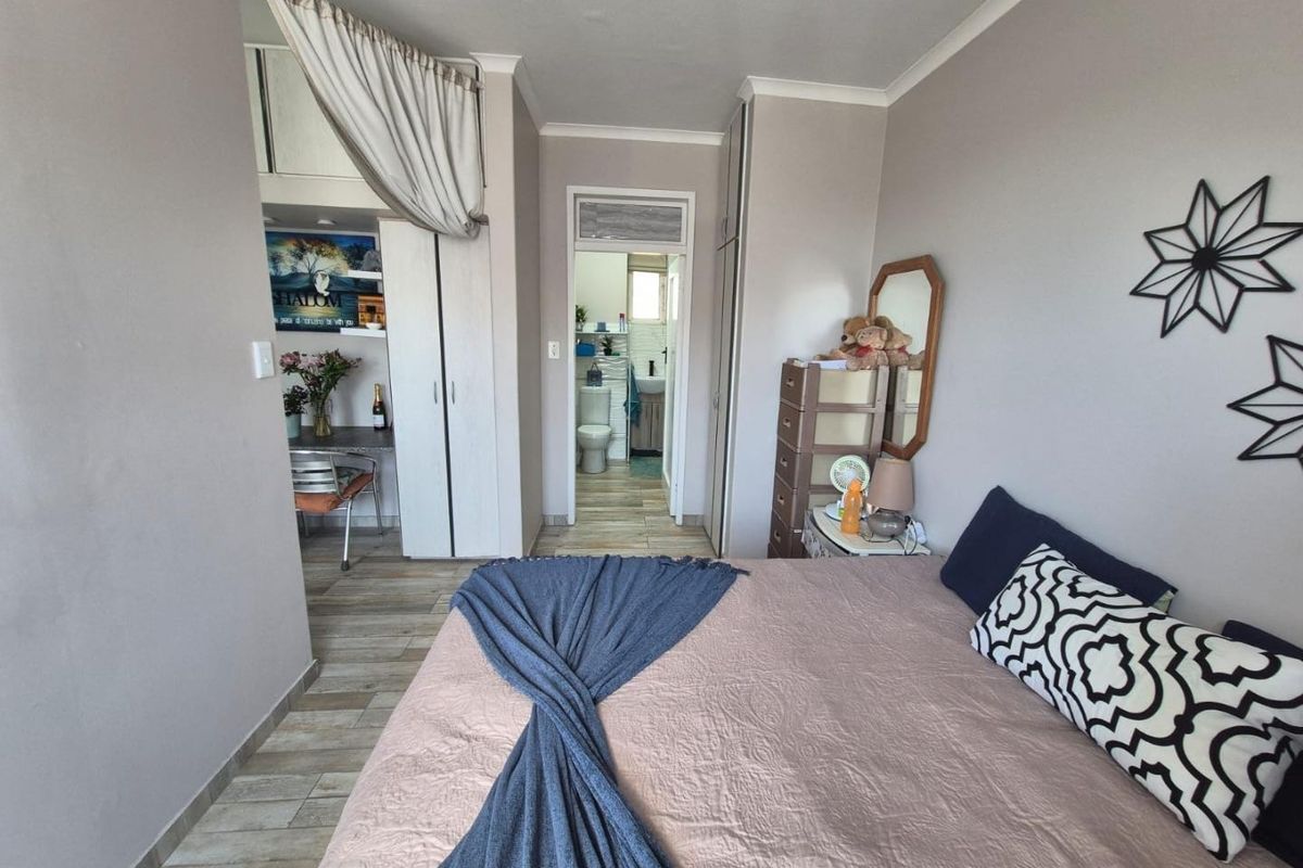 A bedroom featuring built-in cupboards, tiled flooring, and direct access to an en-suite bathroom.