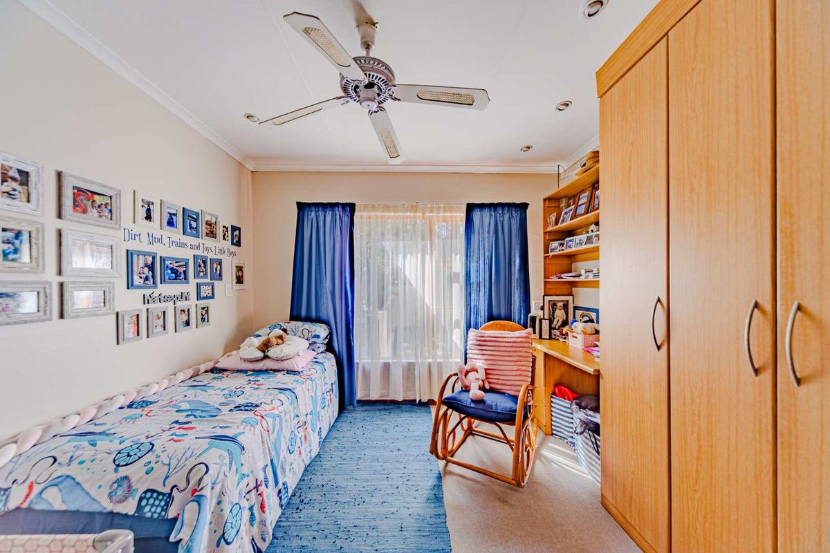A functional bedroom featuring built-in wooden cabinetry, integrated shelving, a ceiling fan, and recessed lighting.